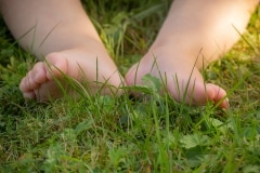 Jente geniet van de grassprieten tussen haar teentjes