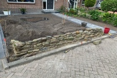 Een muurtje waarop planten moeten groeien, opgebouwd met cement van zavel, rivierzand en traskalk. Helaas slaan de planten nog niet aan.