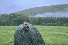 Met tuinstoel, statief en camerarugtas onder de mobiele schuiltent